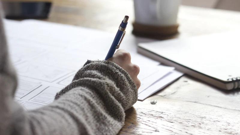 Alumna escribiendo un ejercicio de inglés sobre la mesa